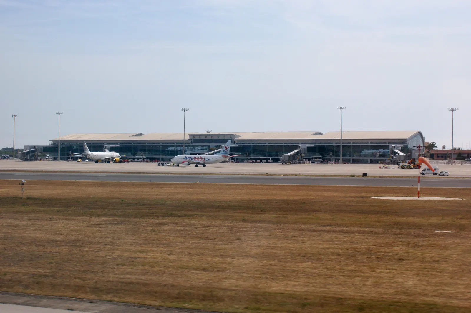La terminal del aeropuerto de Menorca, con dos aviones en la pista y el rótulo de la isla sobre la fachada.