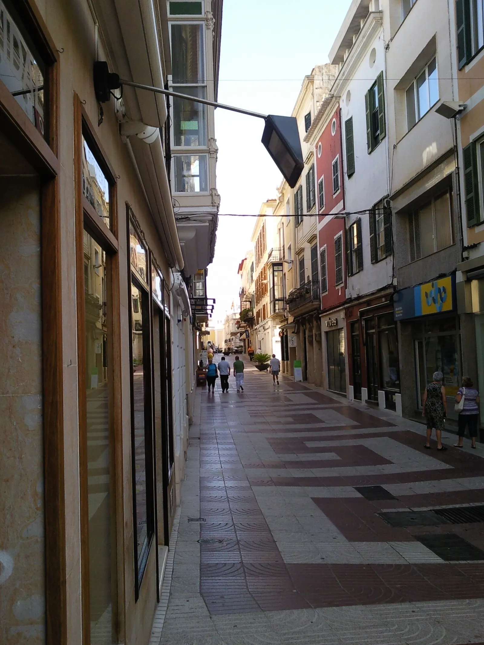 Il Carrer Nou, via pedonale del centro di Maó con la pavimentazione a piastrelle e negozi ai lati