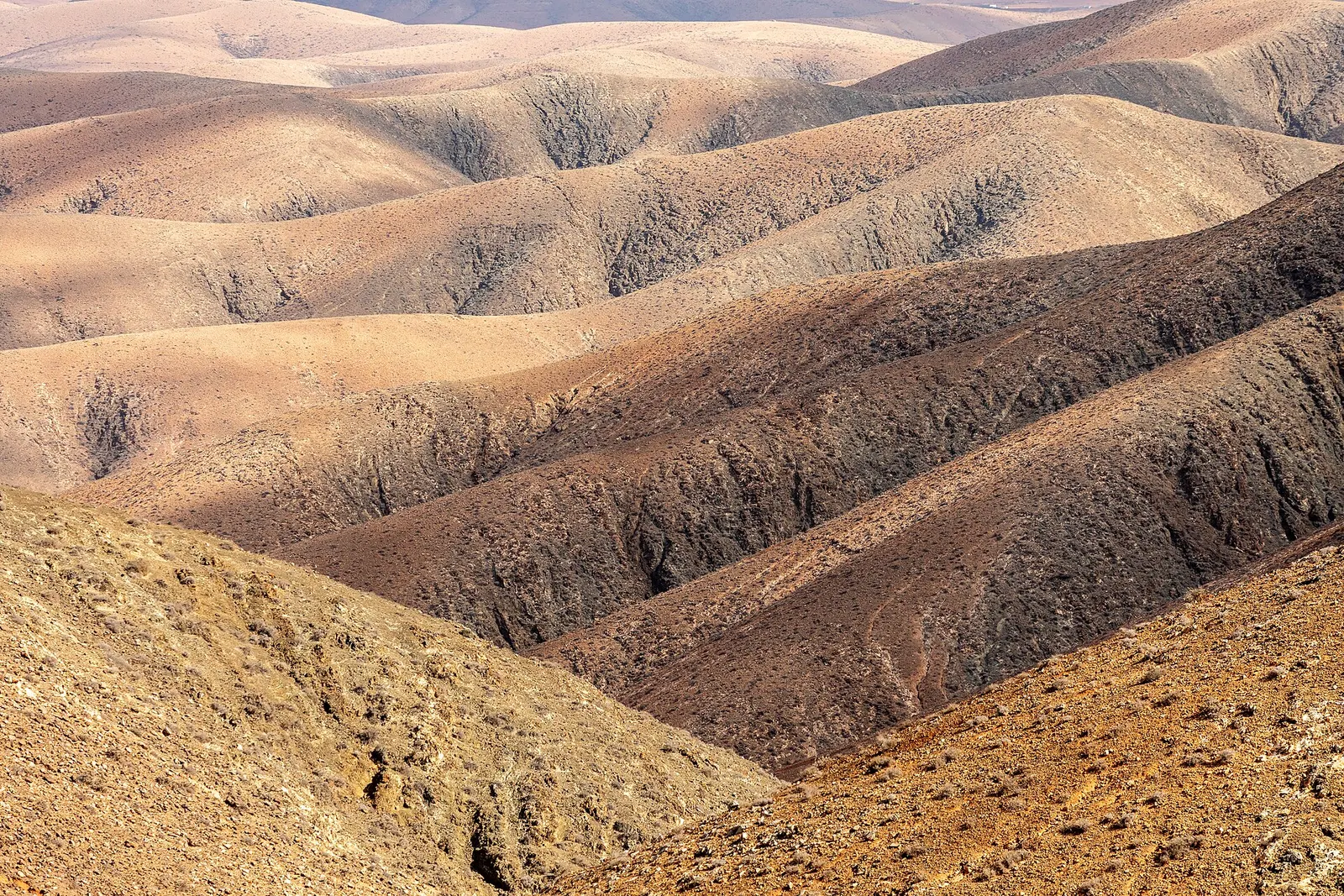 Lomas desnudas en ocres, pardos y dorados se suceden hasta el horizonte, vistas desde el mirador de Sicasumbre.