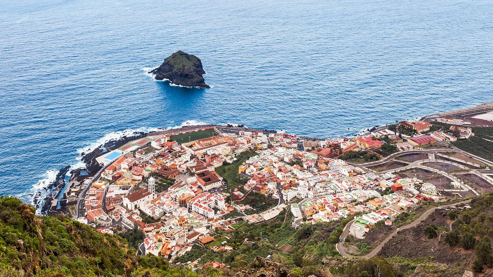 Garachico visto desde lo alto, con su casco sobre la lava, el roque frente a la costa y el Atlántico azul.