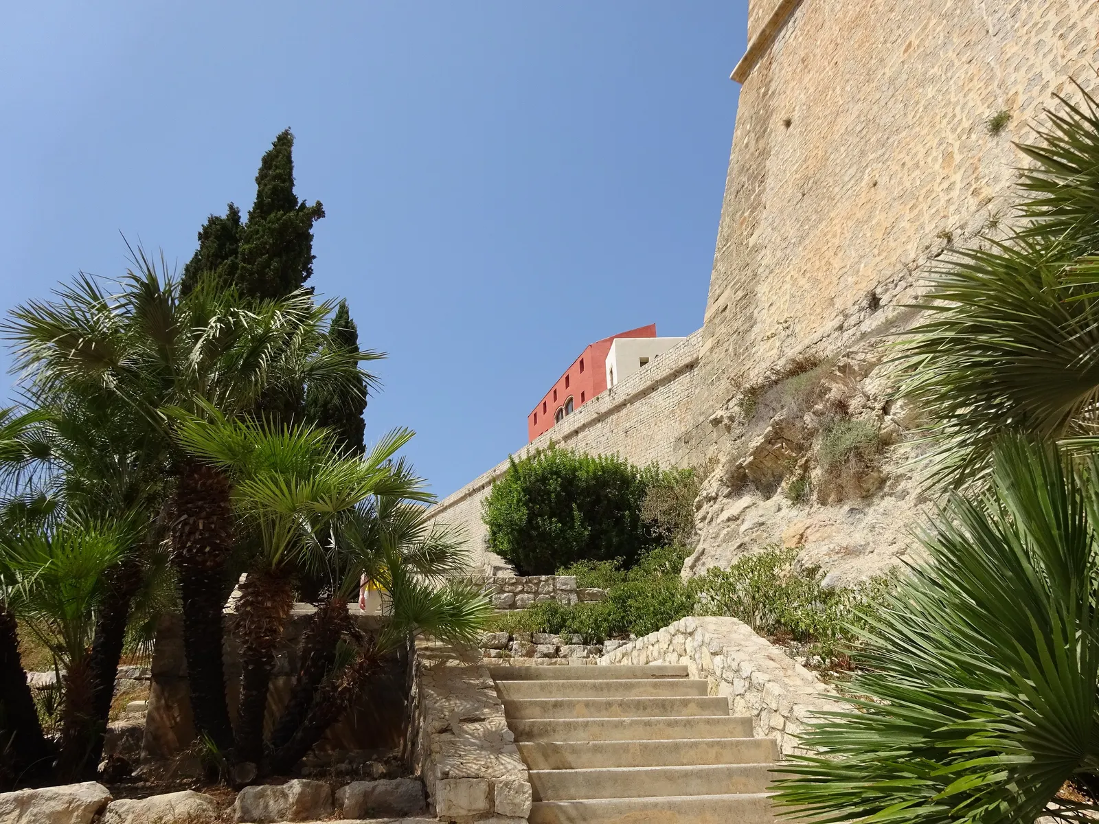 Una escalinata de piedra junto a la muralla de Dalt Vila, en Ibiza, vacía en un día tranquilo.