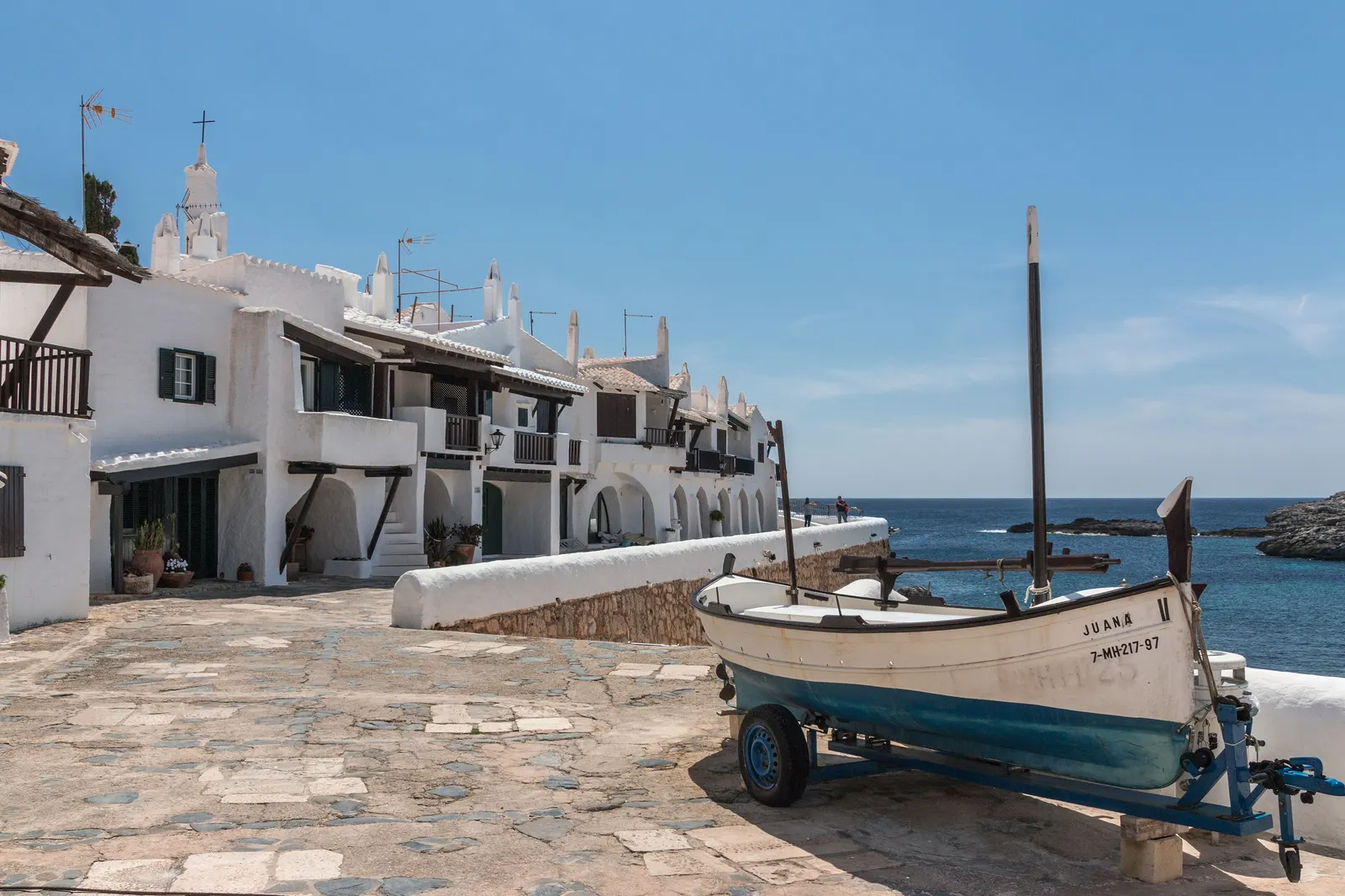 Las casas blancas y escalonadas de Binibeca Vell, junto al mar, sin una sola persona.