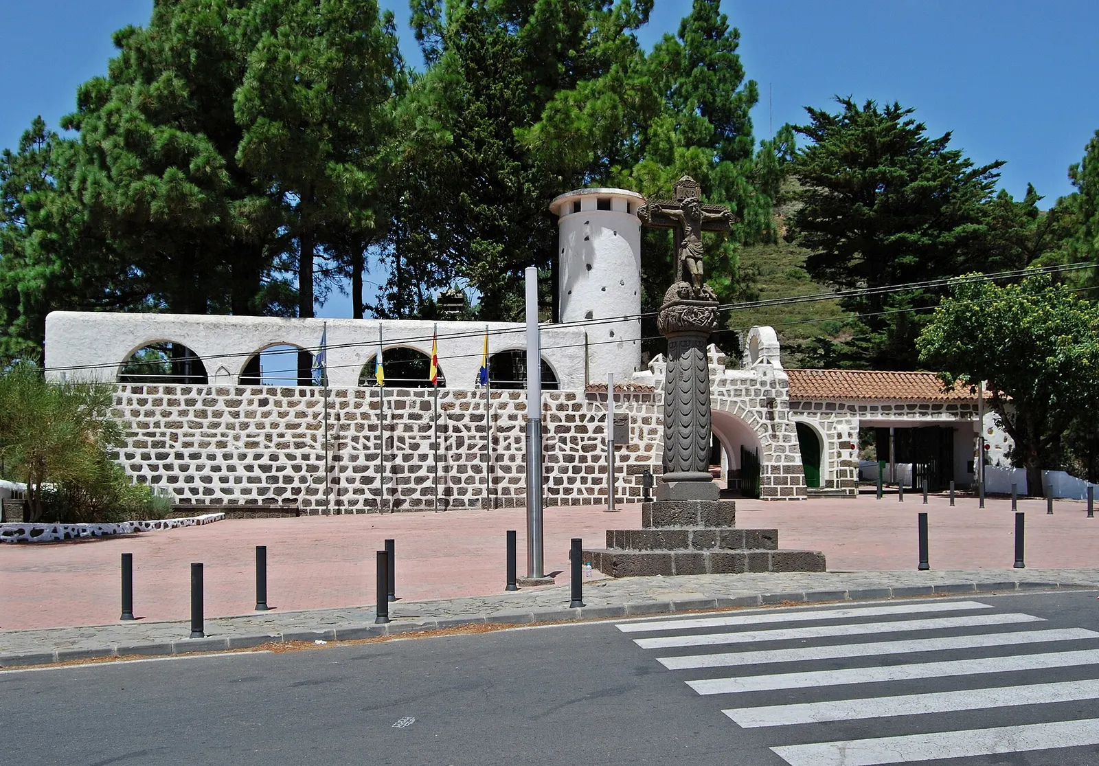 La cruz de piedra de Cruz de Tejeda en el cruce de carreteras de la cumbre, ante el Parador y los pinos.