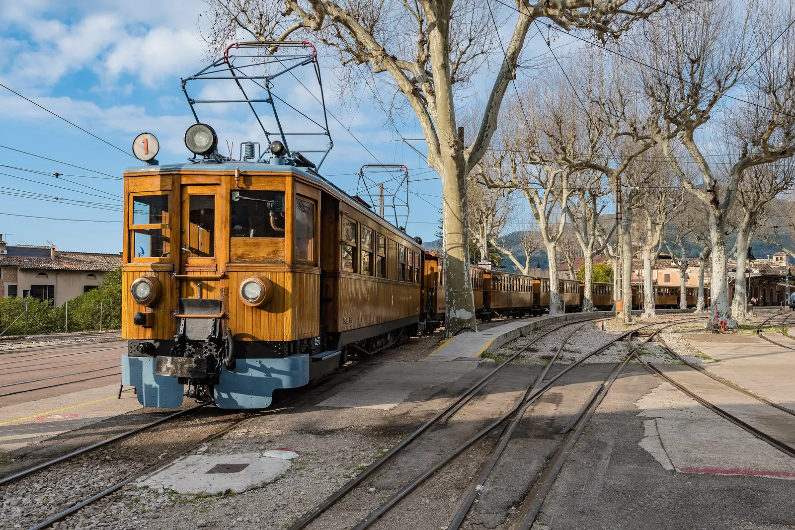 La locomotora del histórico tren de Sóller, con sus vagones de madera, en la estación.