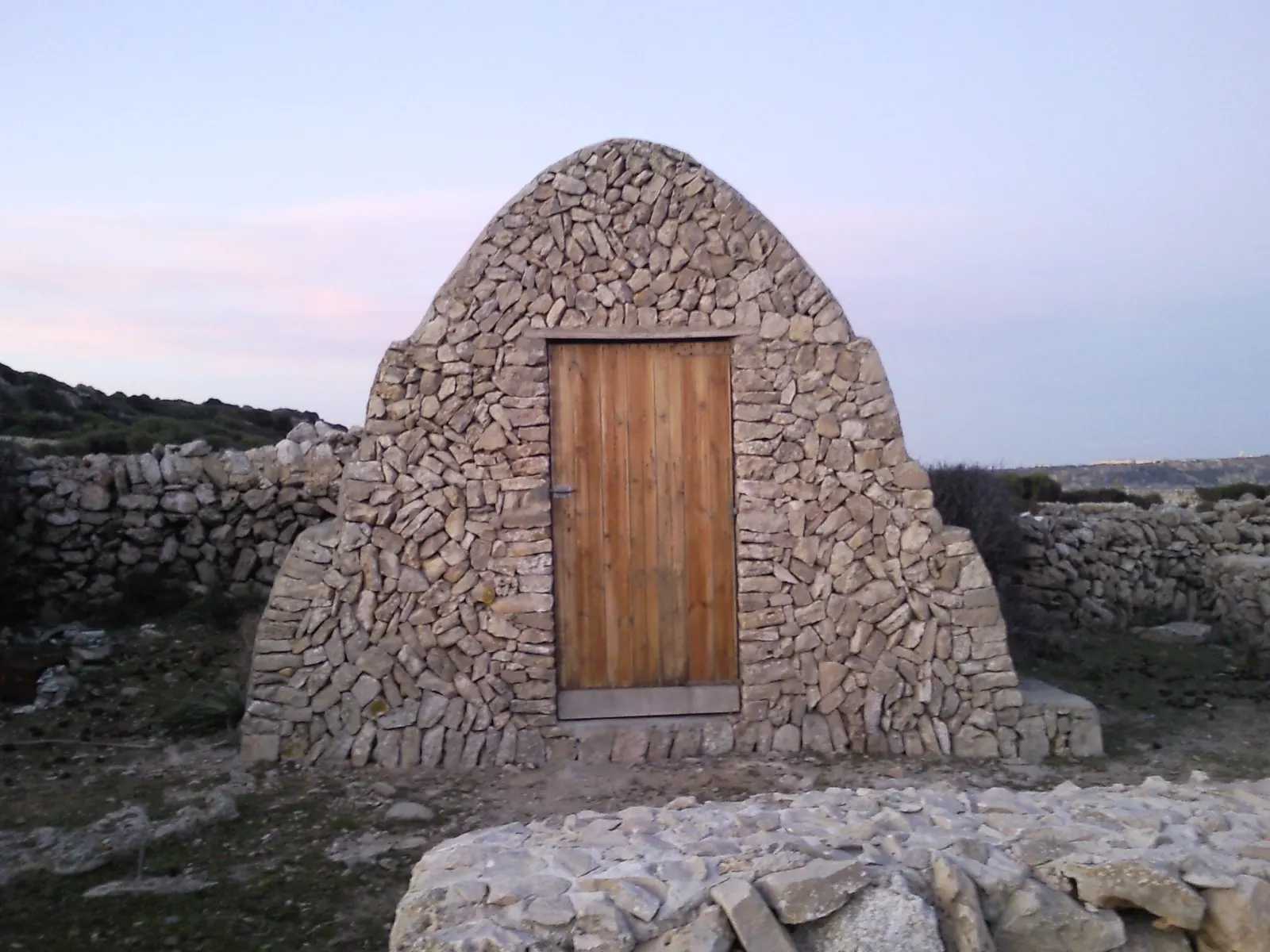 Una barraca de piedra en seco tradicional, con tejado abovedado, en el campo de Menorca.