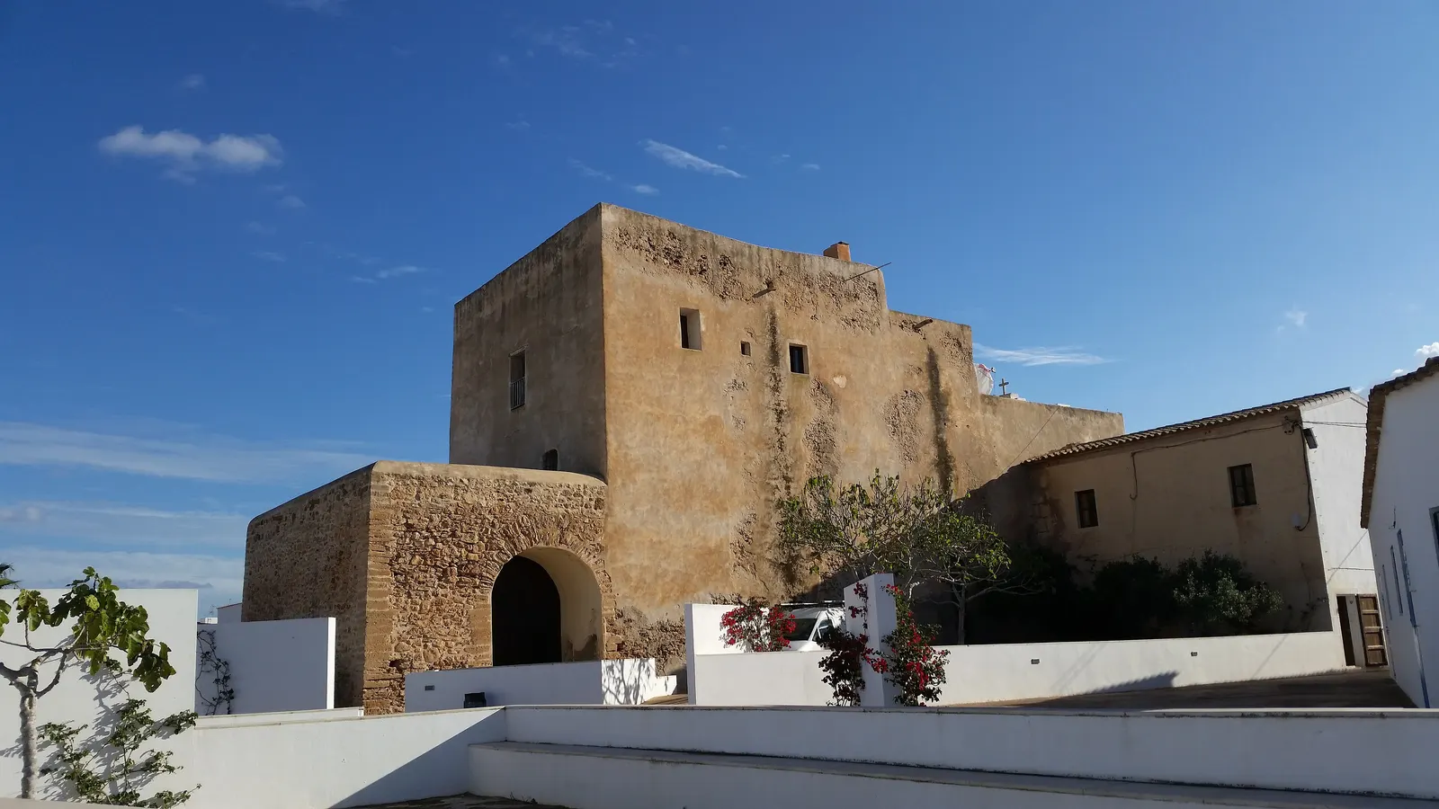 Il retro della chiesa fortificata di Sant Francesc Xavier, a Formentera, con bouganville sul muro.
