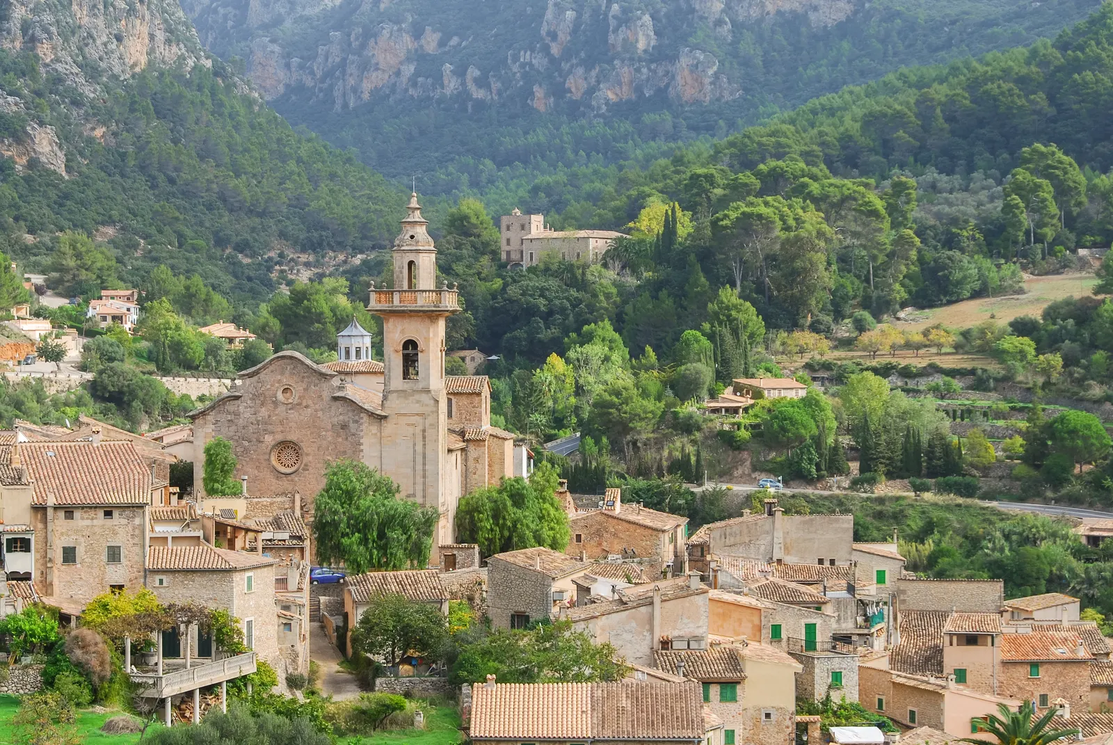 A aldeia de Valldemossa, com a torre da igreja sobre os telhados e a Serra de Tramuntana atrás.