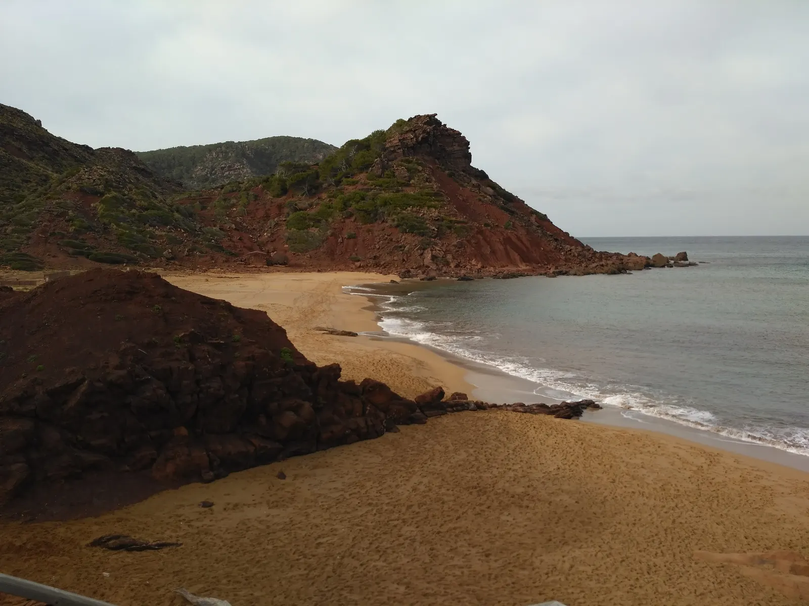 Cala Pilar, una playa pequeña y solitaria de arena dorada entre acantilados rojizos, al norte de Ciutadella.